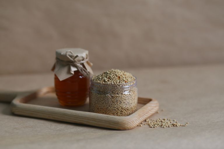 Close-up of glass jars with honey and quinoa, showcasing natural ingredients.